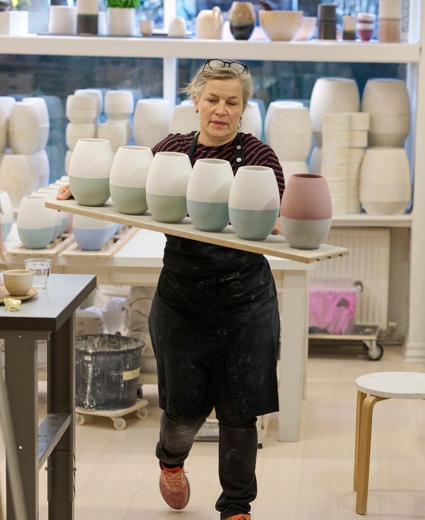 Keramiker Sussi Krull i værkstedsbutikken WAUW design på Østerbro i Købehavn. Hun bærer på en række vaser, som skal ind i keramikovnen og brændes. 